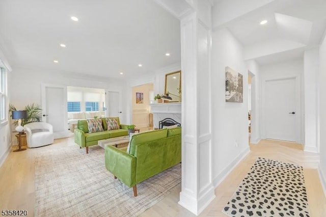 living area featuring a fireplace, recessed lighting, baseboards, and light wood-style flooring