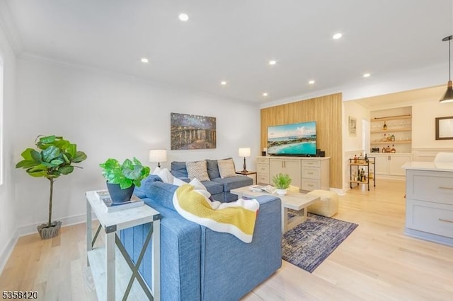 living area with ornamental molding, light wood-style flooring, built in features, recessed lighting, and baseboards