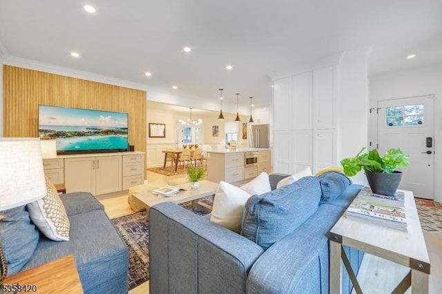 living room featuring a chandelier, recessed lighting, crown molding, and light wood-style floors