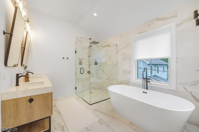 full bath with a marble finish shower, a freestanding tub, marble tiled floors, double vanity, and lofted ceiling