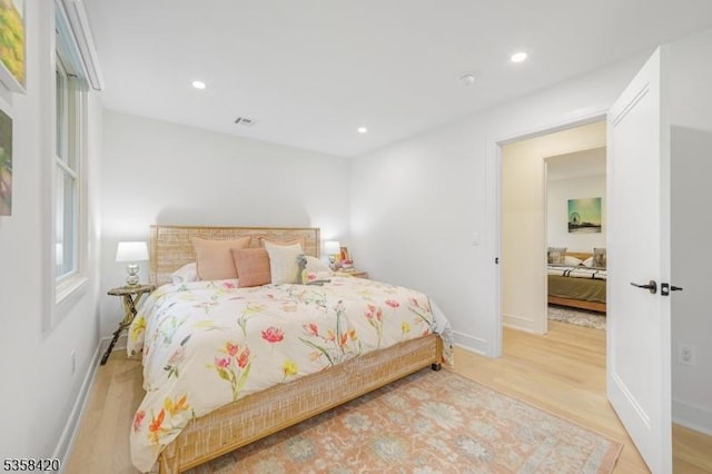 bedroom featuring wood finished floors, baseboards, and recessed lighting