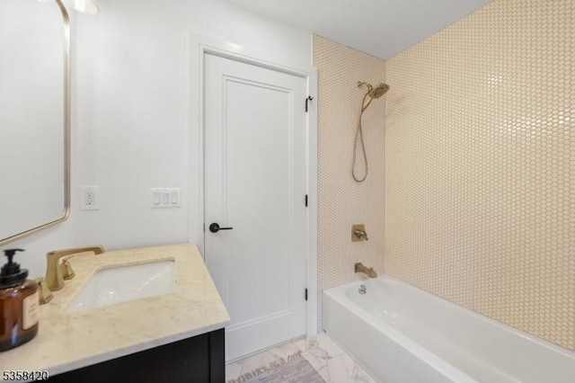 full bath with bathing tub / shower combination, vanity, and marble look tile flooring