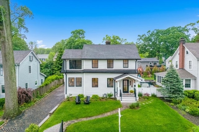 view of front of house featuring a chimney and a shingled roof