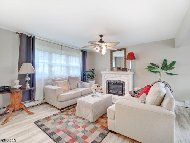living area with light wood-style flooring, a ceiling fan, and a high end fireplace