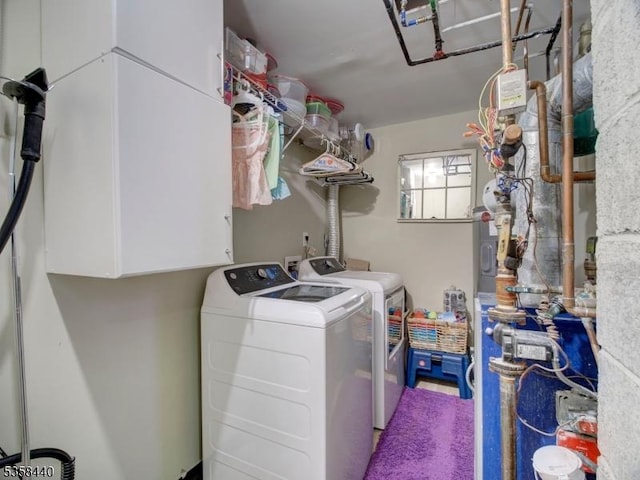 clothes washing area featuring cabinet space and washing machine and dryer