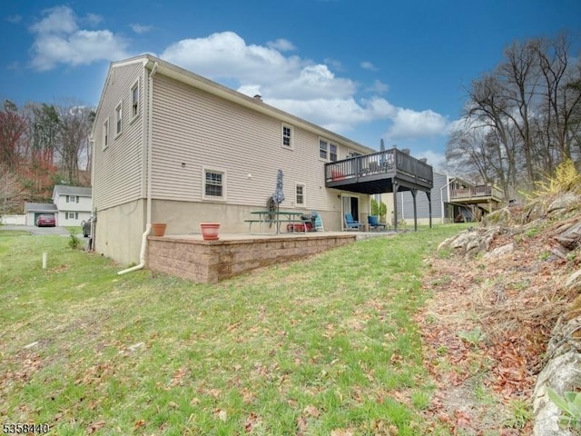 back of house featuring a deck, a yard, and a patio