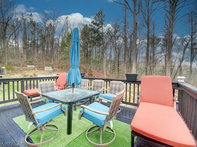 wooden deck with outdoor dining space and a yard
