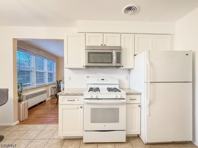 24 Hutton Ave Unit 75, West Orange Twp, NJ 07052 - kitchen with white appliances, radiator, white cabinetry, and light tile patterned floors
