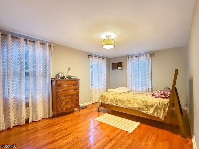 24 Hutton Ave Unit 75, West Orange Twp, NJ 07052 - bedroom featuring wood finished floors, a wall mounted AC, and baseboards