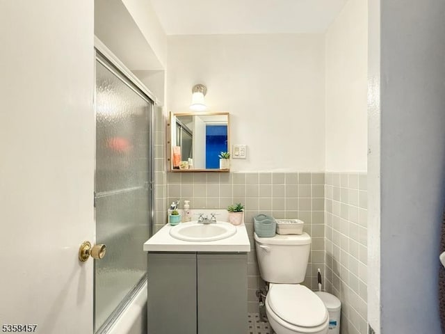 24 Hutton Ave Unit 75, West Orange Twp, NJ 07052 - bathroom with toilet, tile walls, vanity, wainscoting, and enclosed tub / shower combo