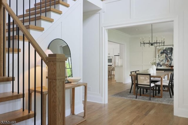 237 Appletree Ln, Mountainside Boro, NJ 07092 - stairway with ornamental molding, wood finished floors, a decorative wall, and a chandelier
