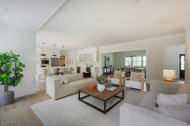 237 Appletree Ln, Mountainside Boro, NJ 07092 - living area with light wood-type flooring, baseboards, a chandelier, and ornamental molding