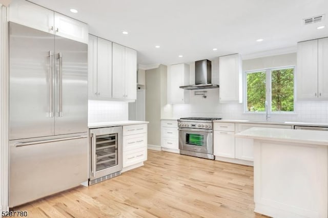 737 Wingate Dr, Bridgewater Twp, NJ 08807 - kitchen with high end appliances, wall chimney exhaust hood, beverage cooler, a sink, and light countertops