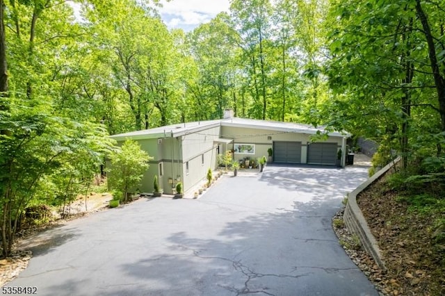 1178 Johnston Dr, Watchung Boro, NJ 07069 - garage with asphalt driveway and a wooded view