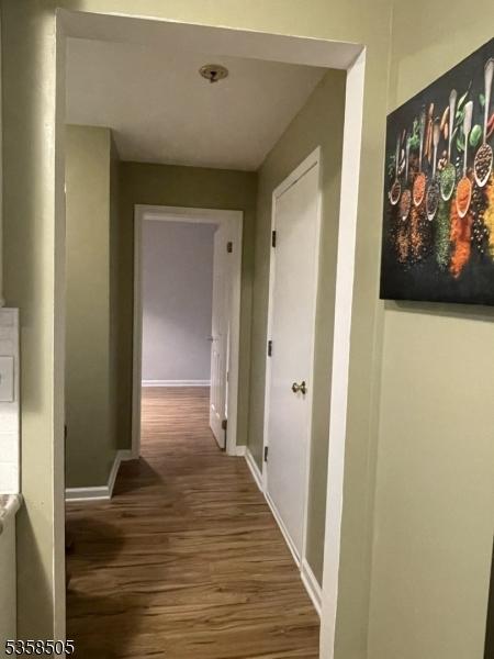 hallway with wood finished floors and baseboards
