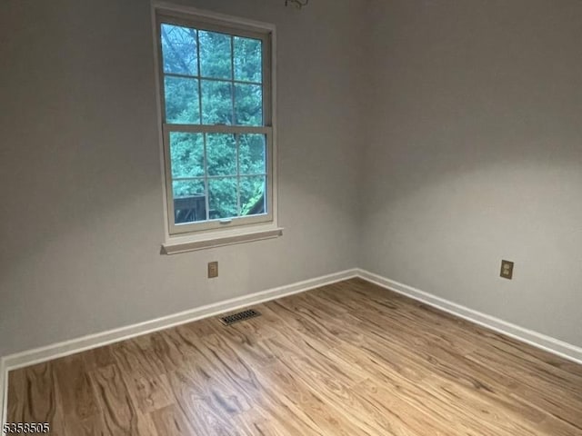 empty room with wood finished floors and baseboards