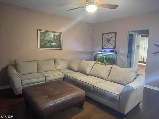 living area with wood finished floors, baseboards, and a ceiling fan