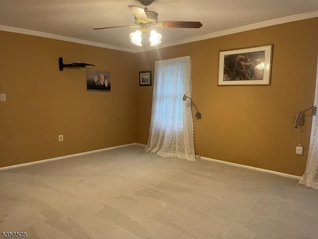 spare room featuring ceiling fan, light carpet, ornamental molding, and baseboards