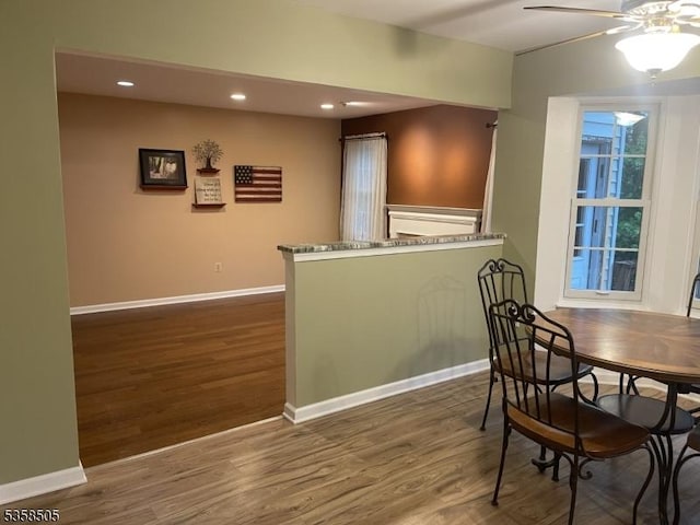 dining space featuring wood finished floors, a ceiling fan, recessed lighting, and baseboards