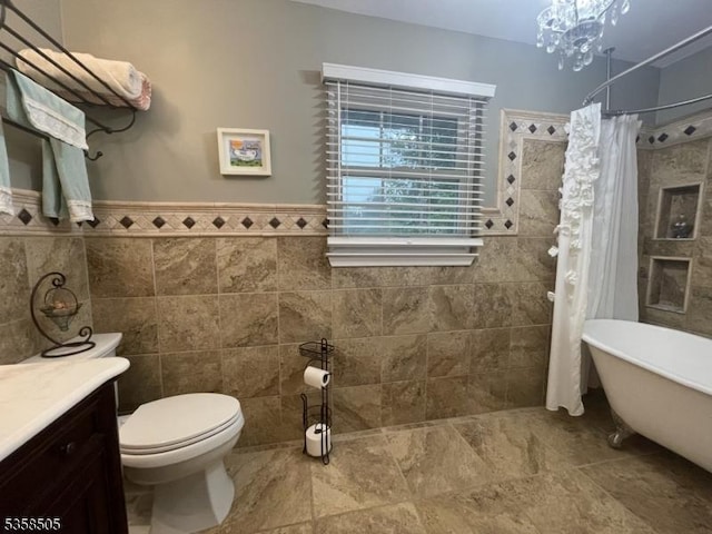 full bath featuring tile walls, vanity, toilet, tiled shower, and a freestanding tub