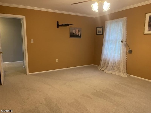 spare room with carpet flooring, baseboards, and crown molding