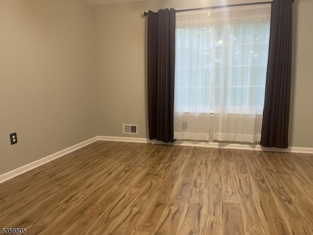 empty room featuring wood finished floors and baseboards
