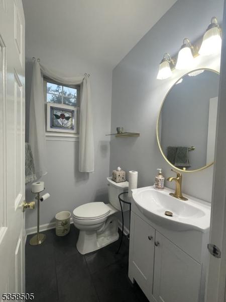 bathroom featuring tile patterned floors, toilet, vanity, and baseboards