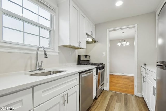kitchen featuring stainless steel appliances, a sink, white cabinetry, light wood finished floors, and recessed lighting