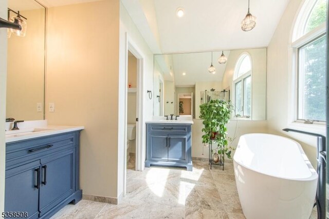 2 Jolie Ct, Boonton Town, NJ 07005 - full bathroom with healthy amount of natural light, two vanities, toilet, a freestanding tub, and lofted ceiling