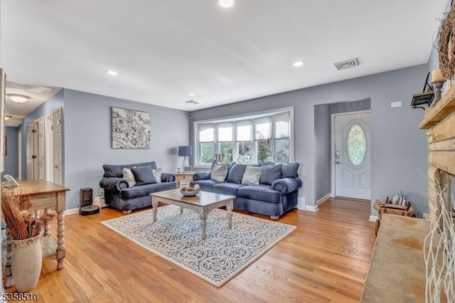 living area with light wood-style floors, a fireplace, baseboards, and recessed lighting
