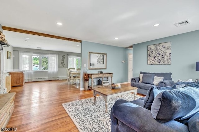 living room featuring baseboard heating, light wood-style floors, and recessed lighting
