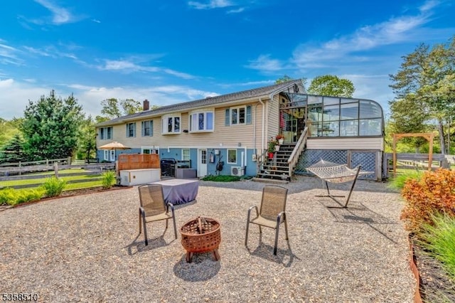 back of property featuring an outdoor fire pit, stairs, a sunroom, and a patio