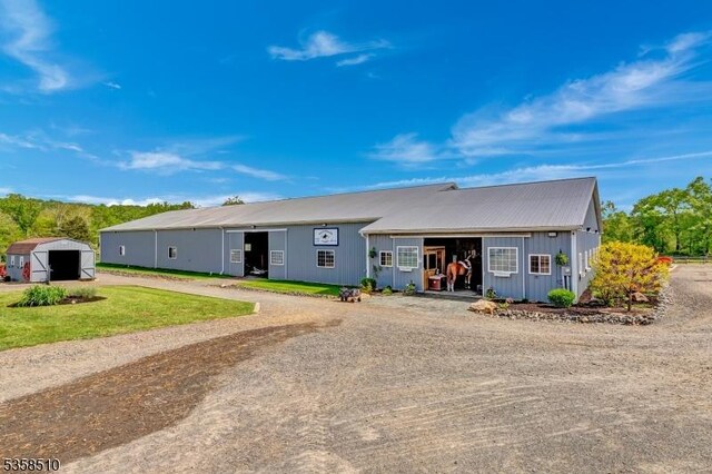 view of front of home featuring dirt driveway and an outbuilding