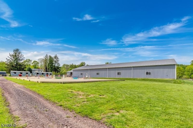 rear view of property with a yard and an outbuilding