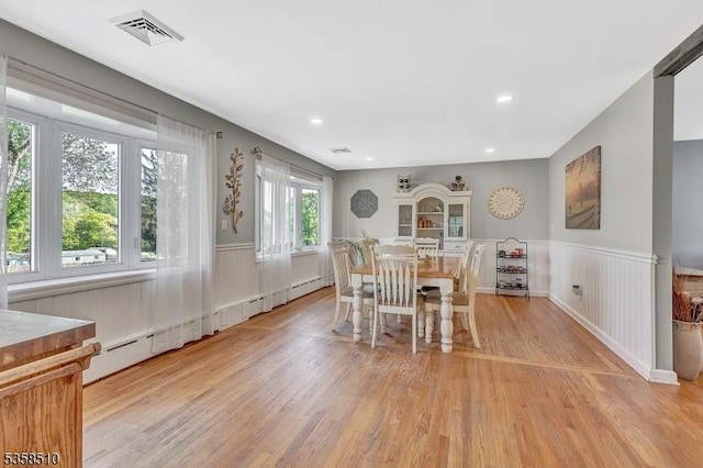 dining space with wood finished floors, wainscoting, baseboard heating, and recessed lighting