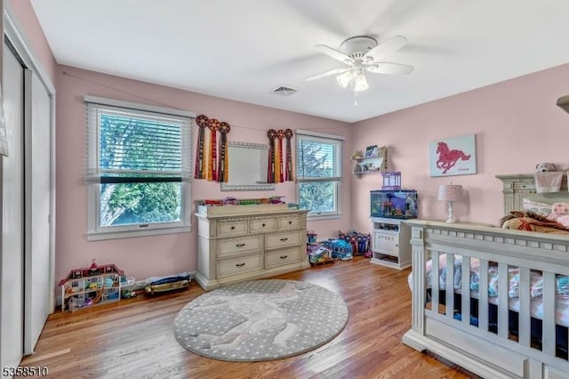bedroom featuring light wood finished floors, a closet, and a ceiling fan