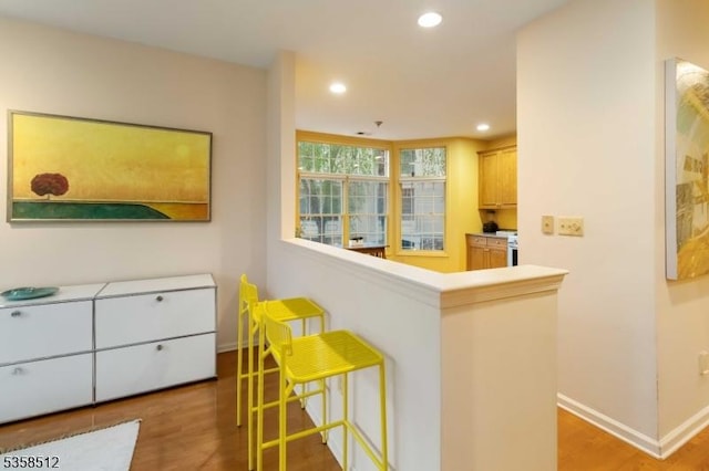 618 Turlington Ct, Livingston Twp, NJ 07039 - kitchen featuring wood finished floors, baseboards, recessed lighting, a kitchen bar, and a peninsula