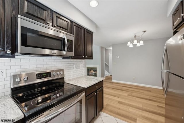 24 Stevens Ct, Bedminster Twp, NJ 07921 - kitchen with stainless steel appliances, dark brown cabinetry, backsplash, and a chandelier