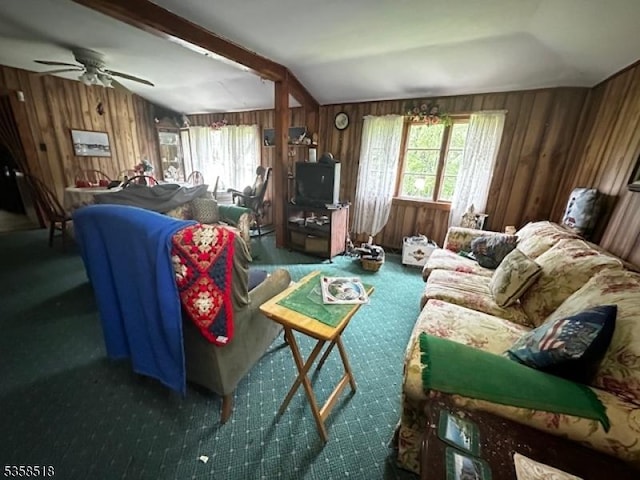 carpeted living area with healthy amount of natural light, wooden walls, and ceiling fan