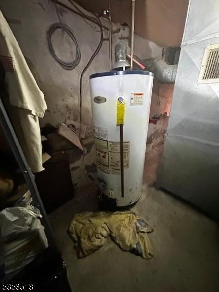 utility room featuring gas water heater and heating unit