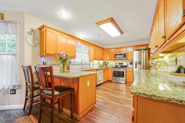 40 Nathan Dr, Old Bridge Twp, NJ 08857 - kitchen featuring appliances with stainless steel finishes, a peninsula, light wood-style floors, and light stone counters