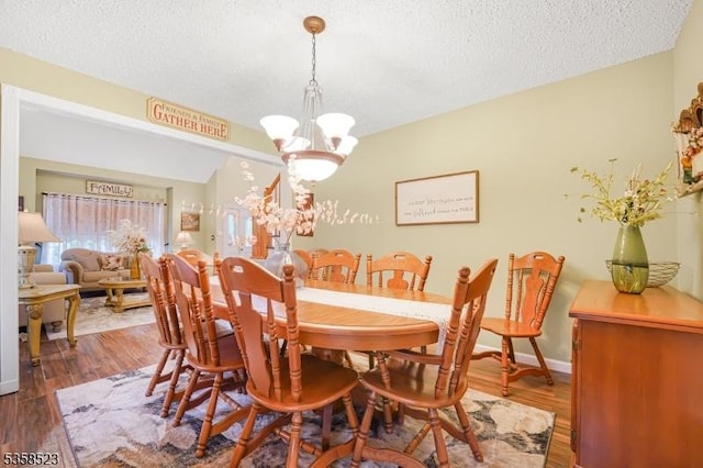 40 Nathan Dr, Old Bridge Twp, NJ 08857 - dining room featuring a chandelier, a textured ceiling, dark wood finished floors, and baseboards