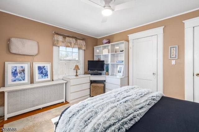 bedroom featuring radiator, wood finished floors, ornamental molding, and ceiling fan