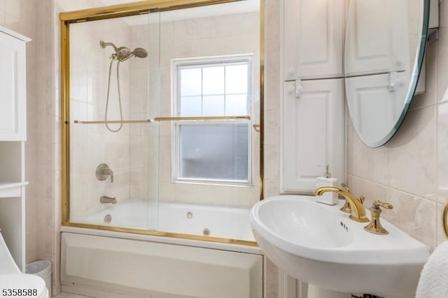 full bath with a sink and combined bath / shower with glass door