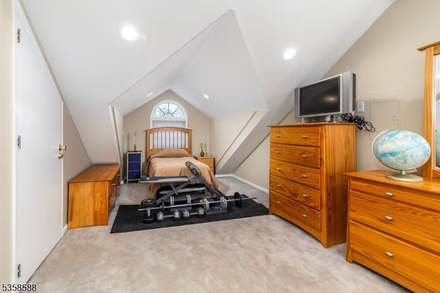 bedroom with vaulted ceiling, light colored carpet, and baseboards