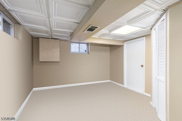 basement featuring baseboards and carpet flooring