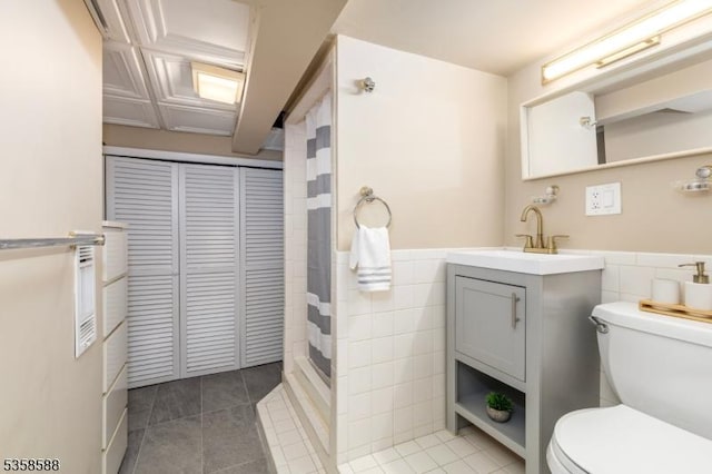 bathroom featuring tile walls, toilet, tile patterned flooring, a shower with shower curtain, and vanity
