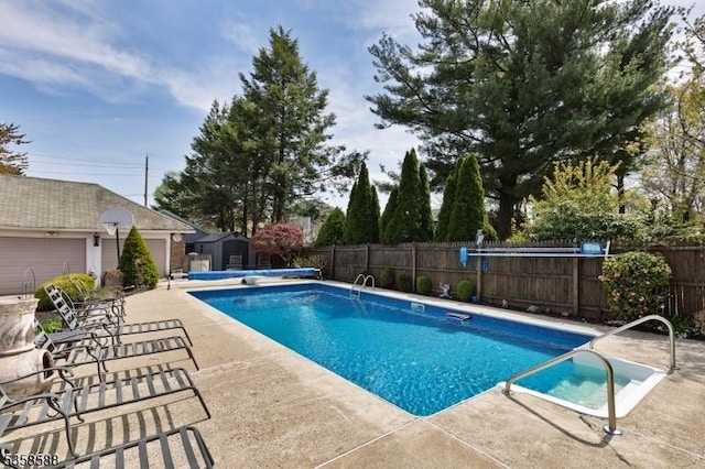 view of pool featuring an outdoor structure, fence, a patio area, a shed, and a diving board