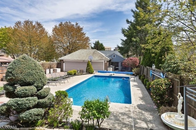 view of pool with a fenced backyard, an outbuilding, and a patio