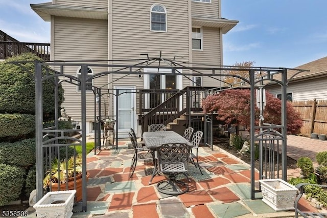 view of patio / terrace with stairway, fence, and outdoor dining space